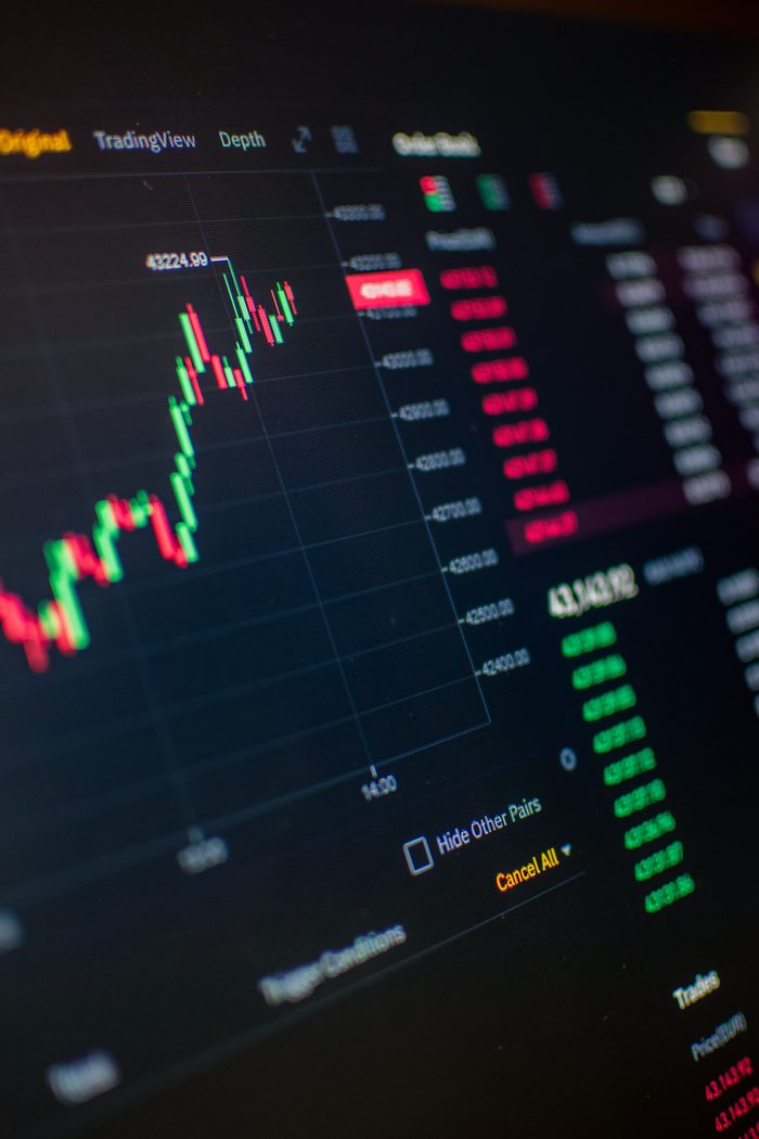 hero-img-02 Close-up of a digital screen showing cryptocurrency market trading graph and data.